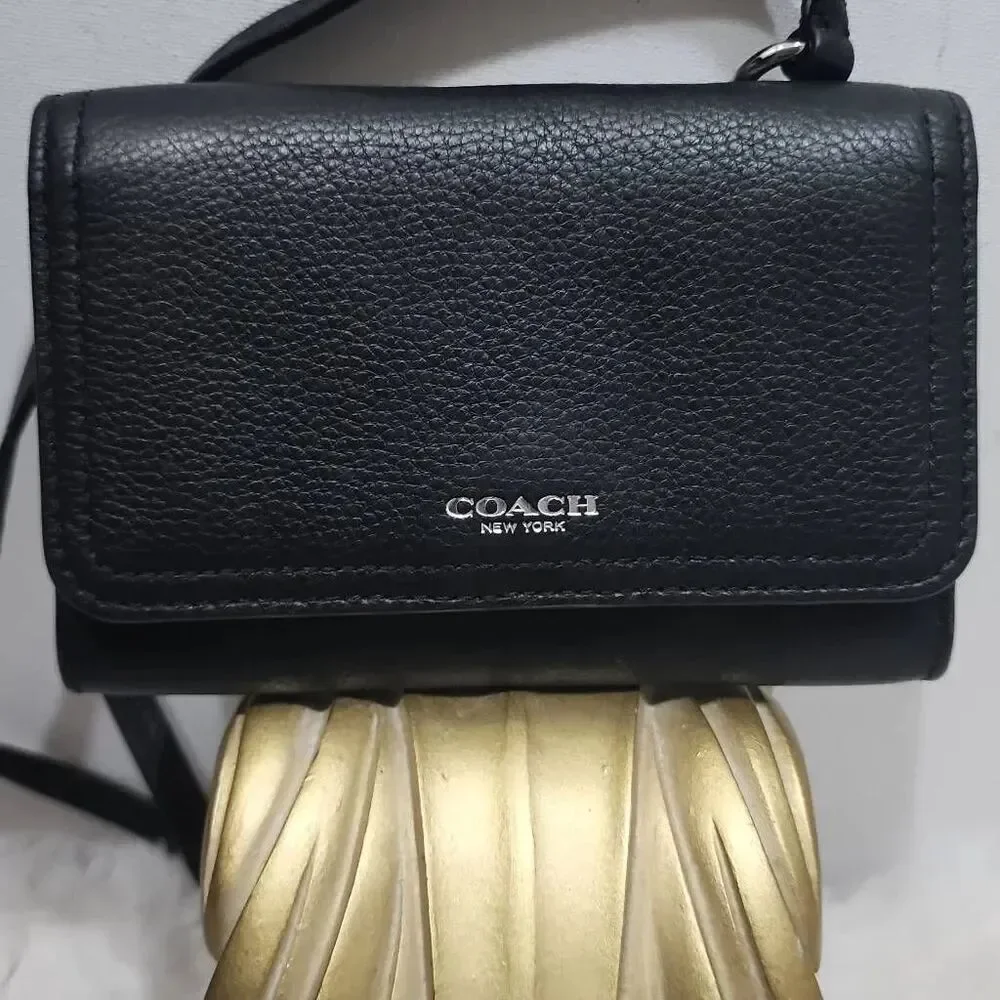 Coach Avery leather phone crossbody w/ a flap closure.